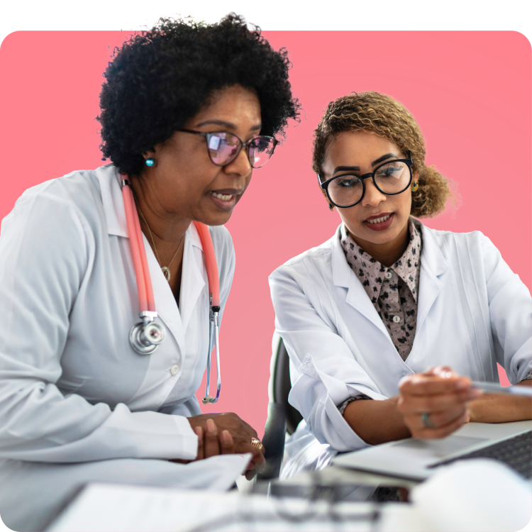 Two healthcare professionals in white coats reviewing information together, representing Q Care Plus community partnerships expanding PrEP access.