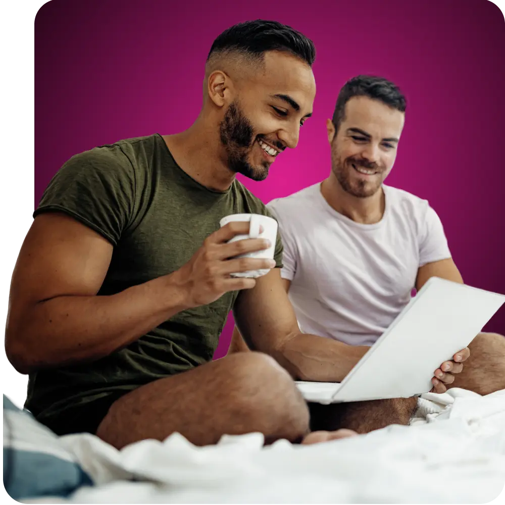 Pareja gay sonriendo y mirando a Q Care Plus.com