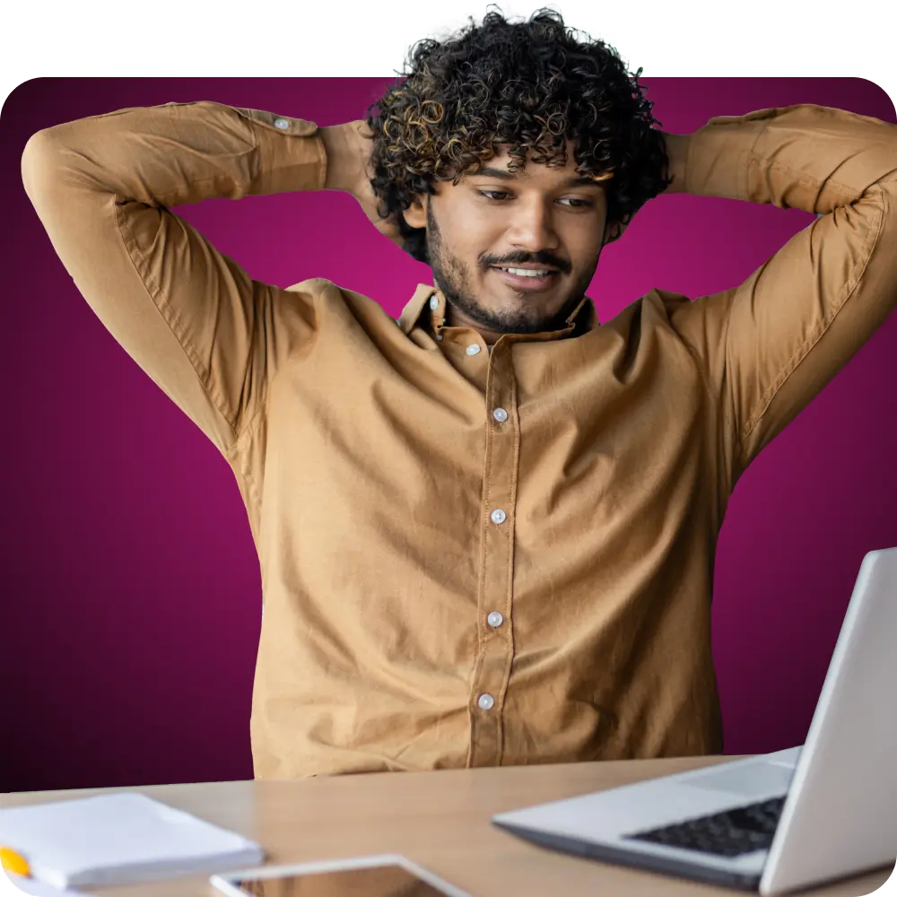 Hombre con los brazos detrás de la cabeza mirando su portátil