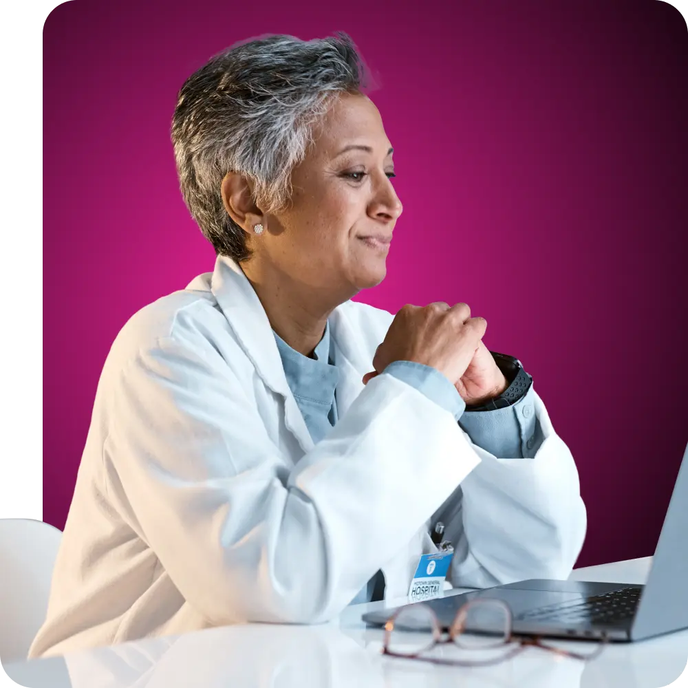 Doctora sonriendo y mirando la pantalla de su portátil