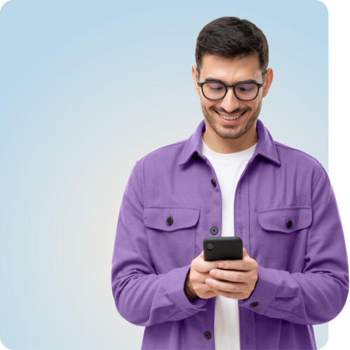 Smiling man in a purple jacket using his phone, representing the ease of booking an online PrEP appointment with Q Care Plus.