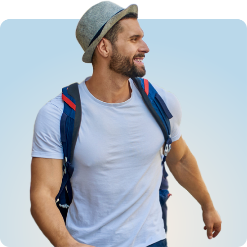 Travel with Confidence, Stay Protected with Q Care Plus Smiling man wearing a hat and backpack representing freedom with Q Care
